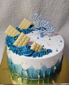 a birthday cake decorated with blue and gold decorations