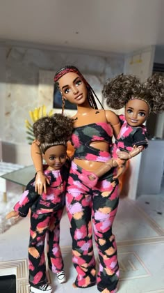 three dolls are posed together in matching outfits