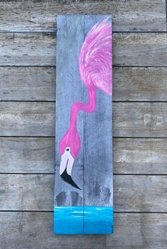 a piece of wood painted with pink flamingos