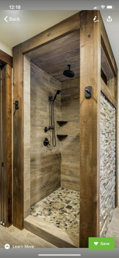 a walk in shower sitting inside of a bathroom next to a wooden wall and floor