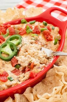 a red casserole dish filled with cheese, tomatoes and jalapenos