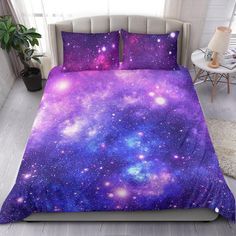 a bed with purple and blue galaxy print on it