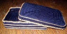 three blue crocheted dishcloths sitting on top of a wooden table