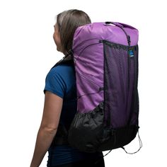 a woman carrying a purple and black backpack