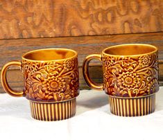 two coffee mugs sitting next to each other on a table