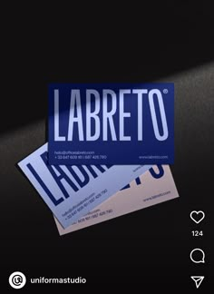 two business cards sitting next to each other on top of a black surface with the word labreto printed on it