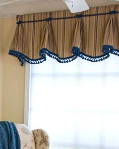 a living room with a couch, chair and window valance on the wall above it