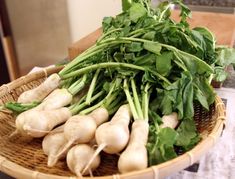 a basket filled with lots of green vegetables