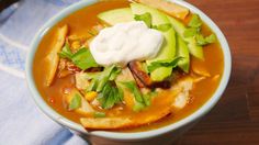 a bowl of soup with avocado and sour cream