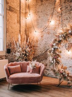 a living room filled with furniture and decor next to a brick wall covered in lights