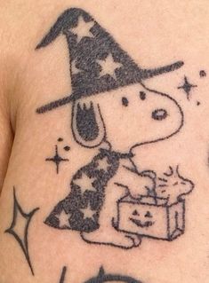 a person with a small tattoo on their chest holding a box and wearing a witches hat