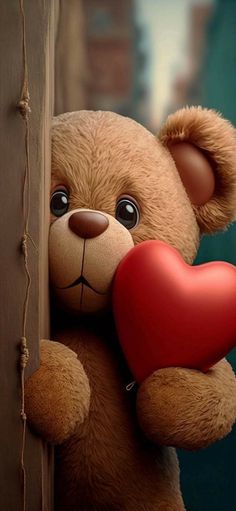 a brown teddy bear holding a red heart