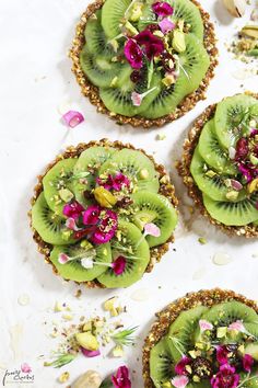 three kiwis with flowers and seeds on them are arranged in the shape of pies