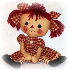 a doll with red hair sitting on a white surface next to a black and white wall