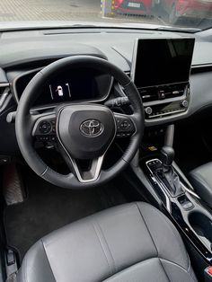 the interior of a car with dashboard, steering wheel and display screen showing information about vehicles