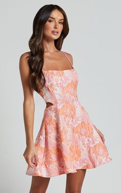 Get ready to turn heads in the Lauraine Mini Dress! This stunning pink and orange floral dress features a strappy straight neck and a flattering fit & flare silhouette. Made from high-quality jacquard polyester, this sleeveless mini dress is perfect for any party or day out. The back cut-out adds a touch of sophistication to this already chic ensemble. Embrace your feminine side with confidence and style in the Lauraine Mini Dress - because you deserve to feel amazing, no matter the occasion! Pr Pink And Orange Floral Dress, Orange Hoco Dress, Floral Hoco Dress, Classy Dresses Short, Semi Ideas, Pink Semi Formal Dresses, Unique Hoco Dresses, Pink And Orange Dress, Fancy Clothing