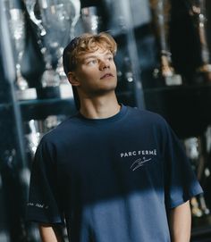 a young man standing in front of many trophies