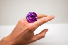 The Loop Ring is a one-banded contemporary acrylic design inspired by its symbolism of love, connection and binding. It also symbolizes good luck, protection and liberation. Each piece is unique and handcrafted allowing for the wearer to style themselves with contemporary wearable design. 100% Acrylic | Handcrafted | Made in Miami Modern Purple Ring For Gift, Modern Purple Rings For Gift, Acrylic Ring, Wearables Design, Contemporary Ring, Acrylic Designs, Knot Ring, Color Ring, Style Expert