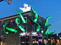 a large green octopus sculpture on top of a building