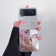 a person holding up a phone case with hello kitty stickers on the front and side