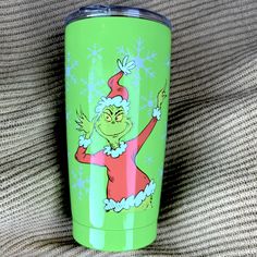 a green christmas mug with the grin on it