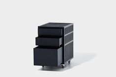 three drawers are stacked on each other in front of a white background and the bottom drawer is black