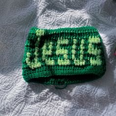 a green crocheted purse sitting on top of a bed