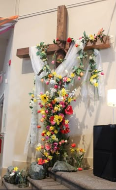 the cross is decorated with flowers and greenery