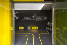 the entrance to an airport with yellow and black markings on the walls, as well as signs