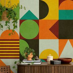 a living room with colorful geometric wallpaper and potted plant on the side table