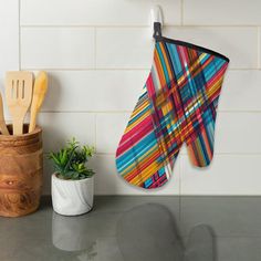 kitchen utensils hanging on the wall next to a pot holder and spatula