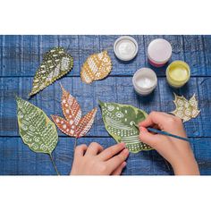 someone is painting leaves with acrylic paint