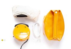 the contents of a yellow purse are laid out next to each other on a white surface