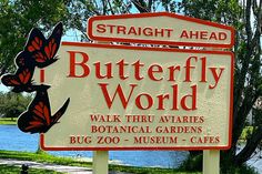 a sign that says butterfly world with two butterflies on it