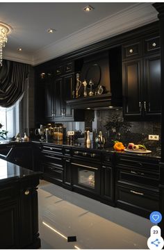 a kitchen with black cabinets and marble counter tops