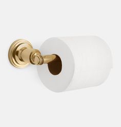 a gold toilet paper holder with two rolls of toilet paper hanging from it's side