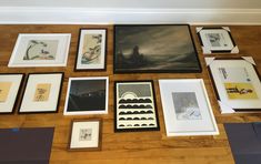 many framed and unframeed art pieces on a wooden floor