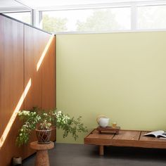 a wooden table sitting next to a green wall