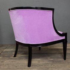 a purple and black chair sitting on top of a wooden floor next to a wall