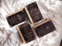 three brown books sitting on top of a white blanket