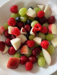 a white bowl filled with assorted fruits