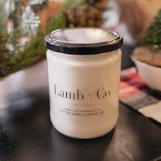 a white candle sitting on top of a table next to pine cones and other christmas decorations