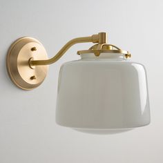 a wall light with a white shade hanging from it's side on the wall