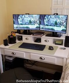 two computer monitors sitting on top of a white desk