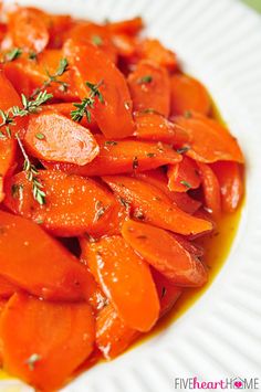 sliced carrots on a white plate with herbs