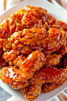 a white plate topped with chicken wings covered in bbq sauce on top of a table