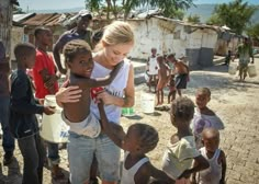 a woman holding a child in front of other children