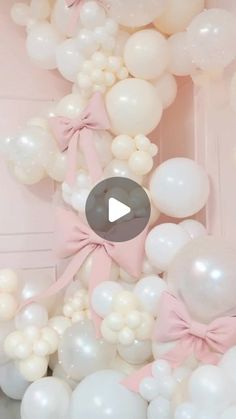 the balloon arch is decorated with white and pink balloons, bows, and streamers