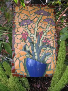 a blue vase sitting on top of a patch of grass