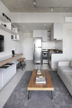 a living room filled with furniture and a flat screen tv mounted on the wall above a wooden coffee table